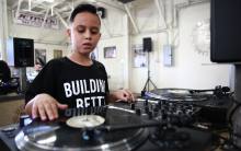 A young student learns to scratch at the Beat Junkie Institute of Sound